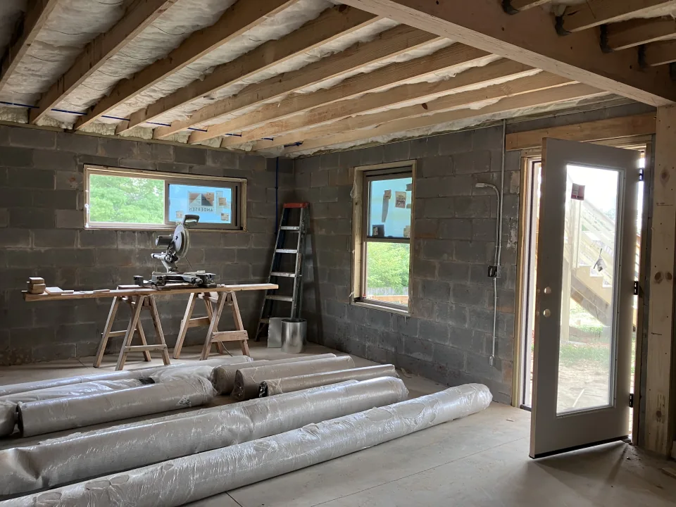 Lower-level room with block wall, windows, and insulation materials