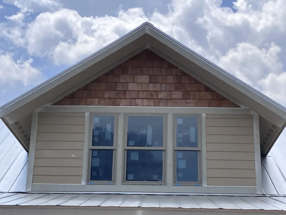 Upper windows, siding, and cedar shingles on a home exterior