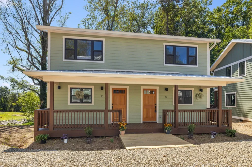 Pawpaw duplex: covered front porches with metal roofs and wood railings at 21 and 23 Fireside Drive