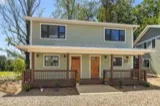 Pawpaw duplex: covered front porches with metal roofs and wood railings at 21 and 23 Fireside Drive