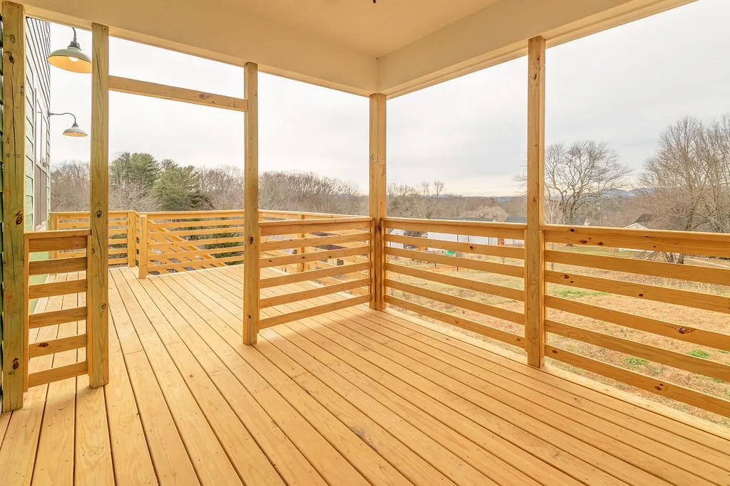 Covered wood porch overlooking trees and nearby mountains