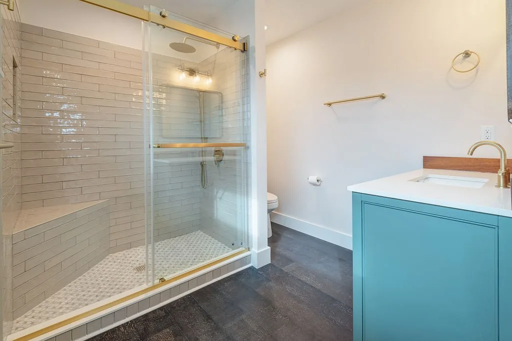 Bathroom with tiled walk-in shower and blue vanity