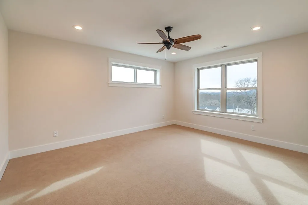 Carpeted bedroom with windows and mountain views