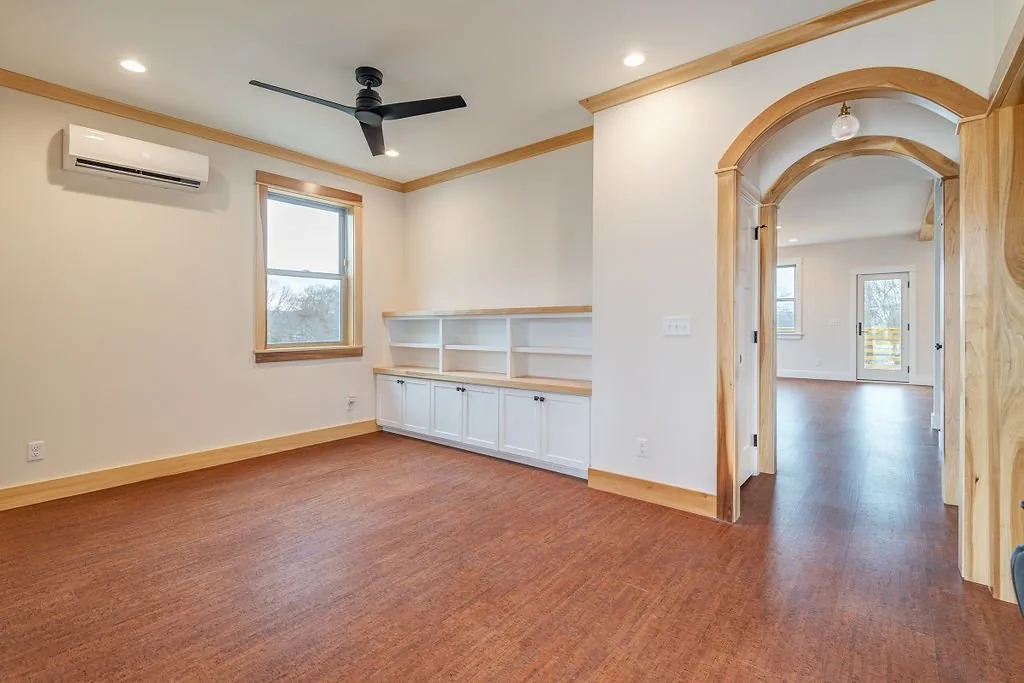 Front room with built-in shelving and arched wood openings