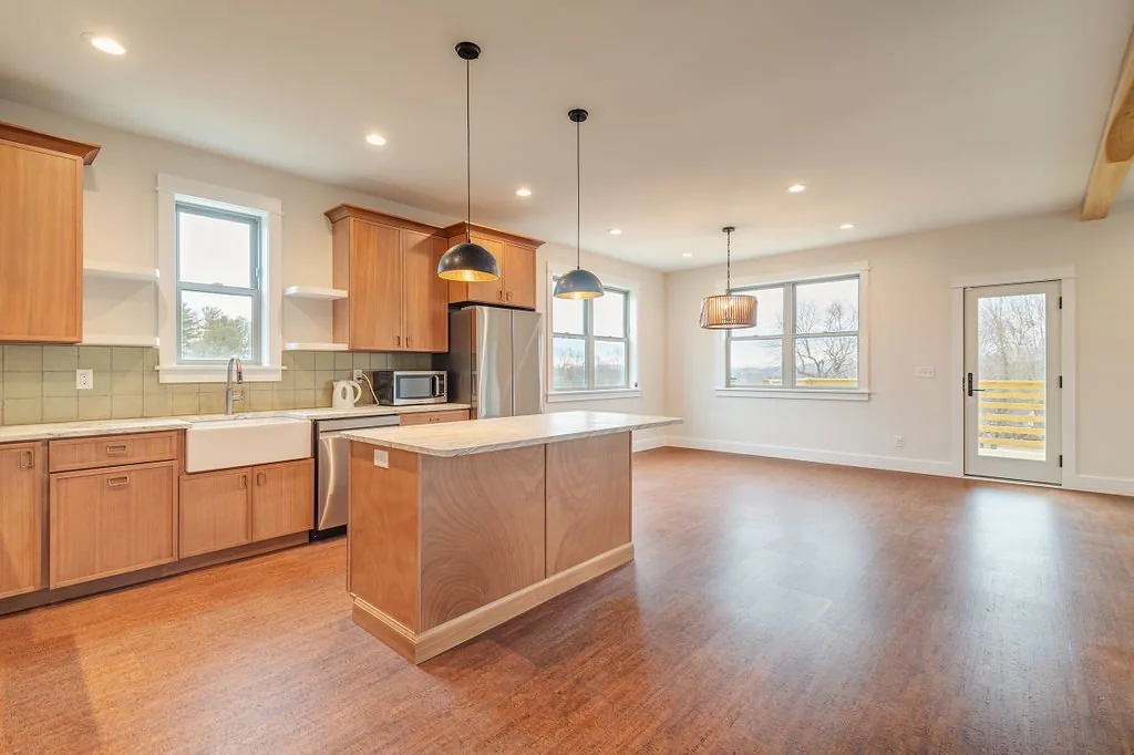 Open kitchen with wood cabinetry, island, and adjoining dining area