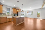 Open kitchen and dining: granite countertops, eucalyptus cabinetry, farmhouse sink, and island