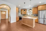 Custom eucalyptus cabinetry and arched passageways off the kitchen