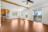 Open living, dining, and kitchen with sliding door to the south-facing deck