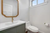 Main-level half bath with brass fixtures and transom window