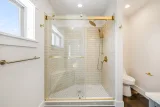 Primary bath: walk-in tiled shower with bench and rain shower head