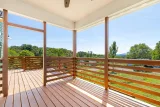 Covered section of the south-facing back deck with ceiling fan and long views