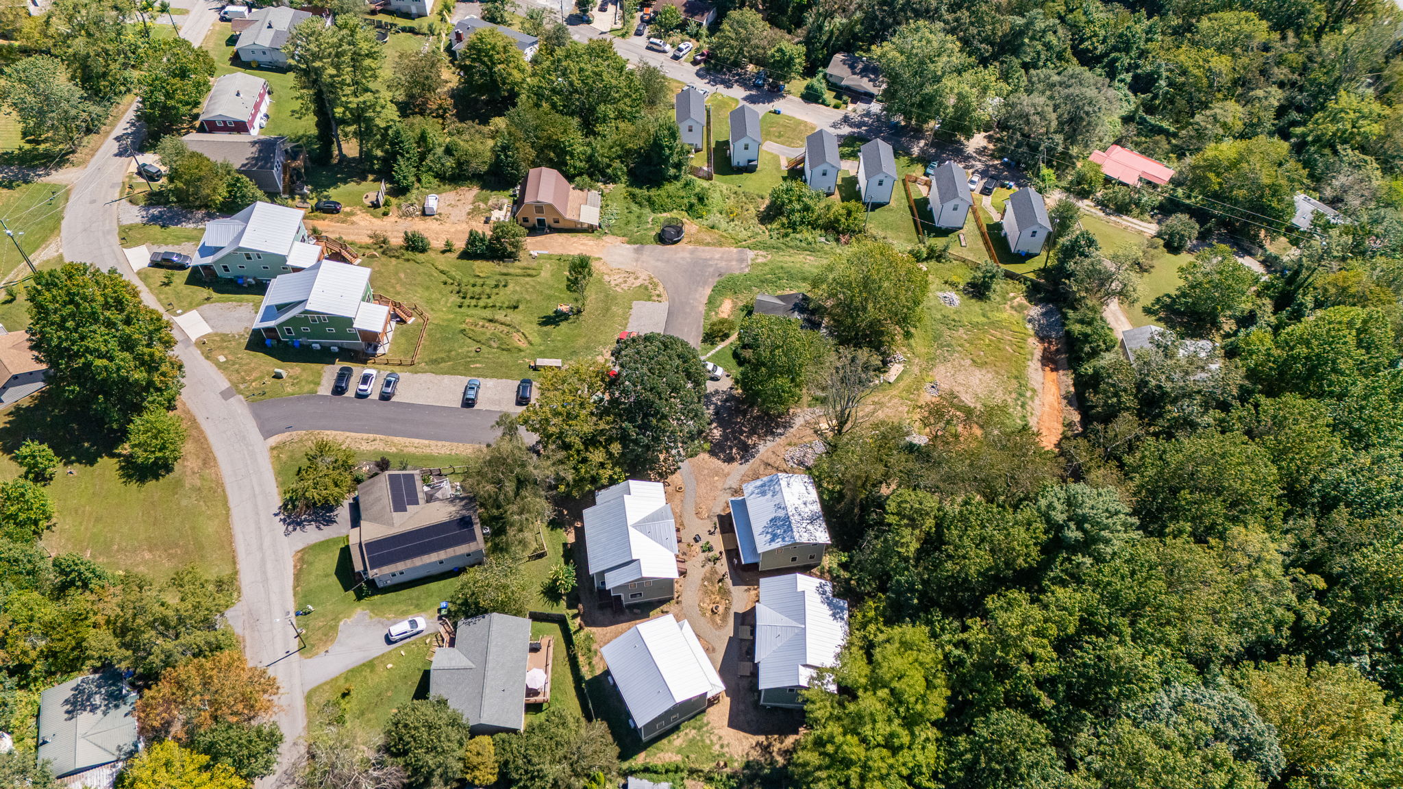 Full site with barn, greenhouse, garden rows, loop lane, and clustered homes