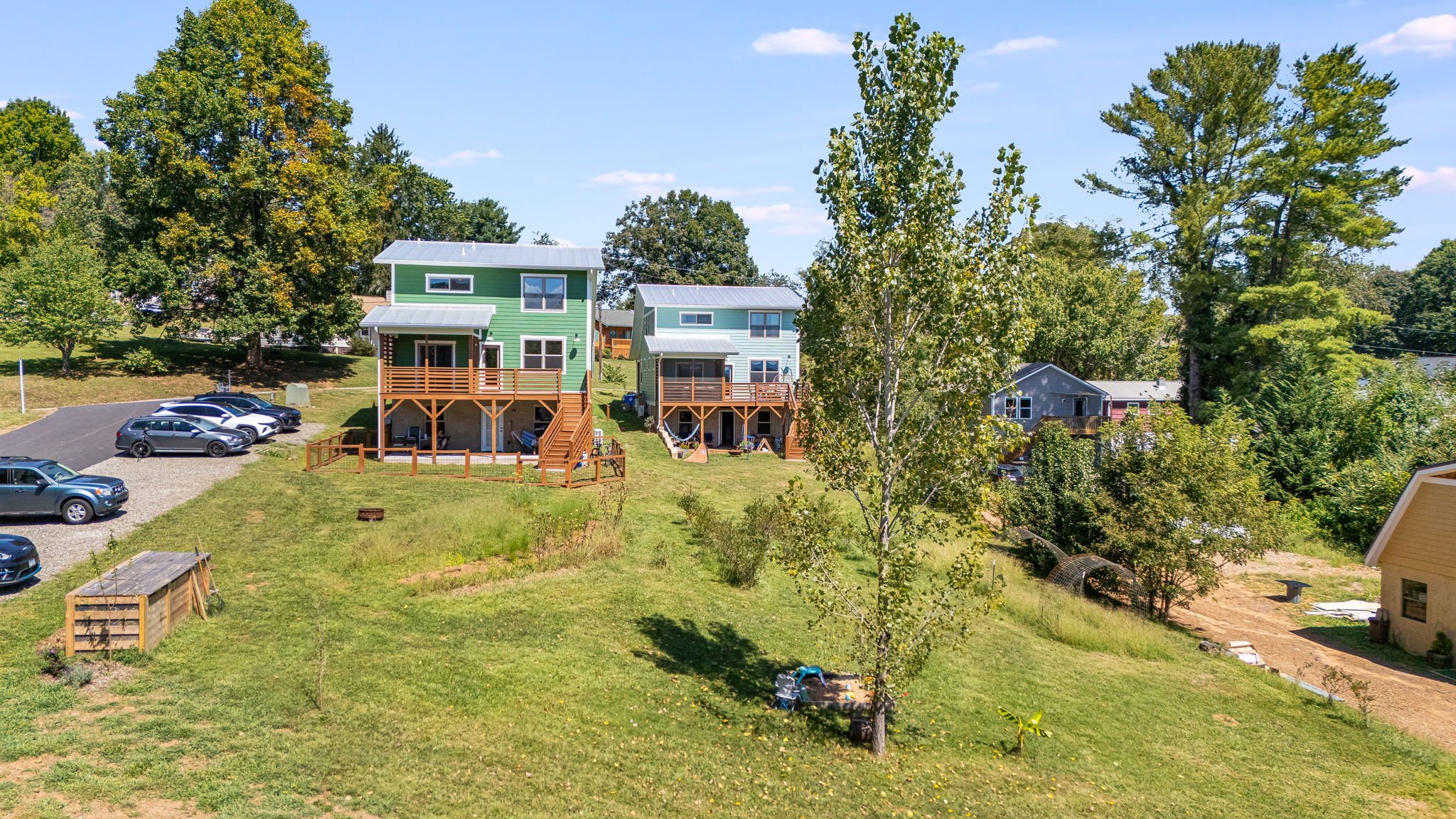 Homes above the meadow with compost bins, fire pit, and gardens